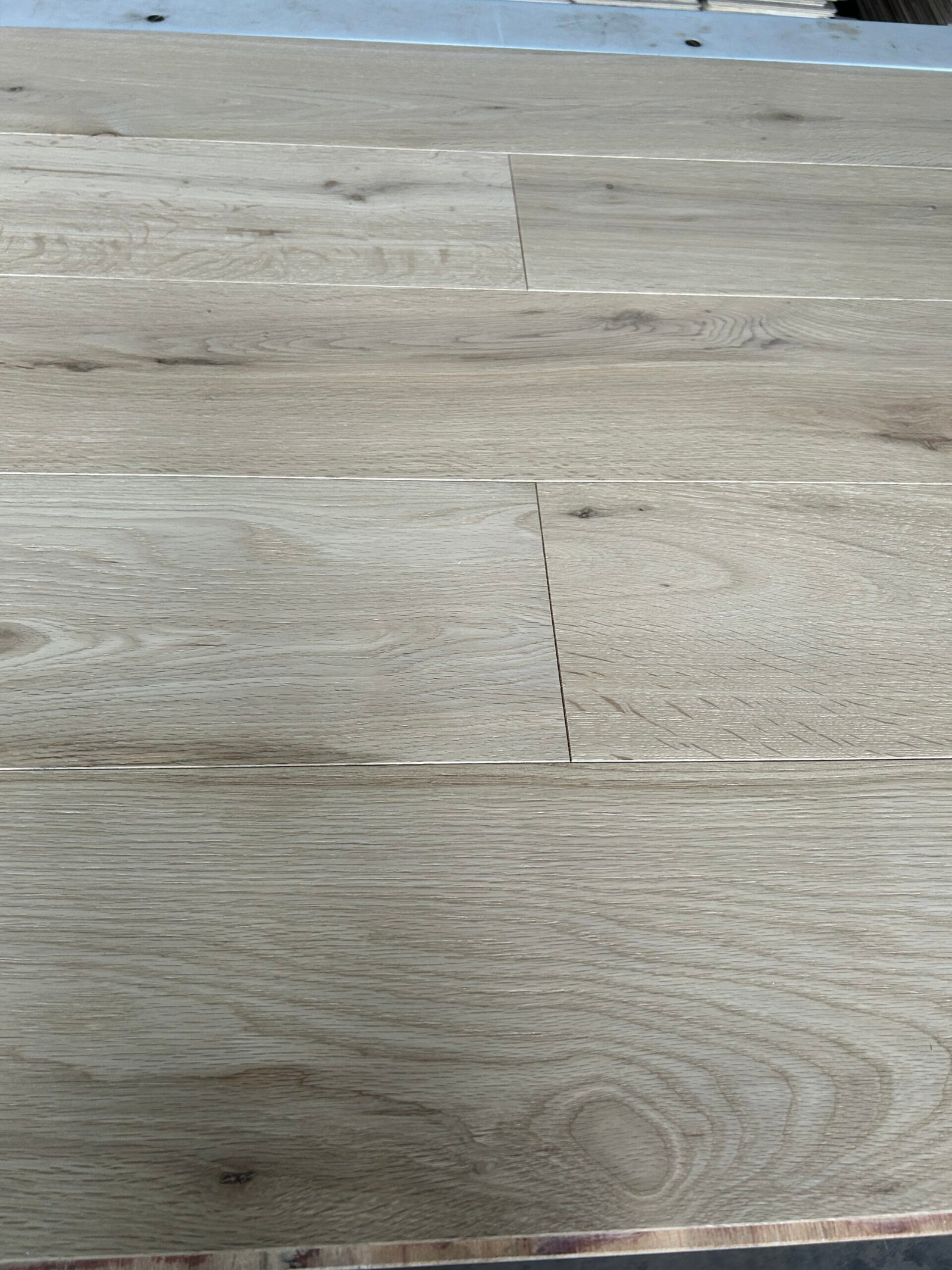 Close-up of Pearl Beige oak boards showing natural grain, visible knots, and staggered board joints