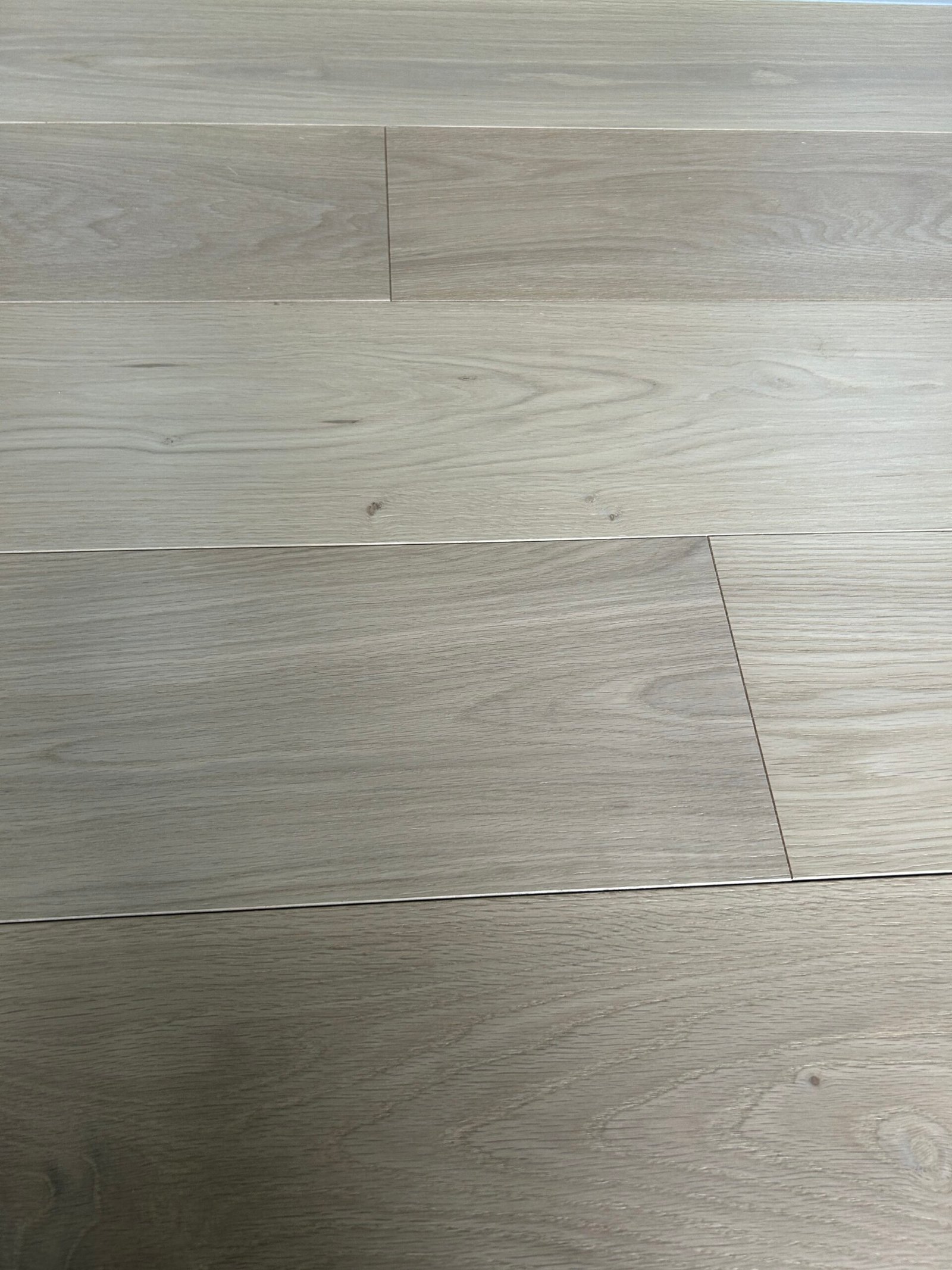 Close view of Pearl Beige oak flooring showing grain patterns, small knots, and staggered board joints