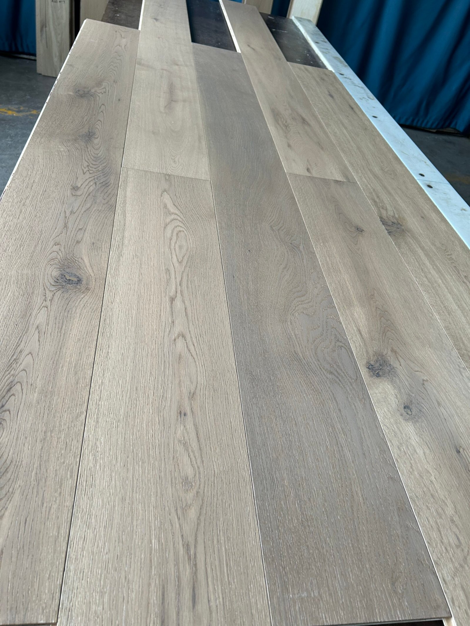 Linen Beige engineered oak flooring boards showing light greige tones, visible knots, and natural grain variation