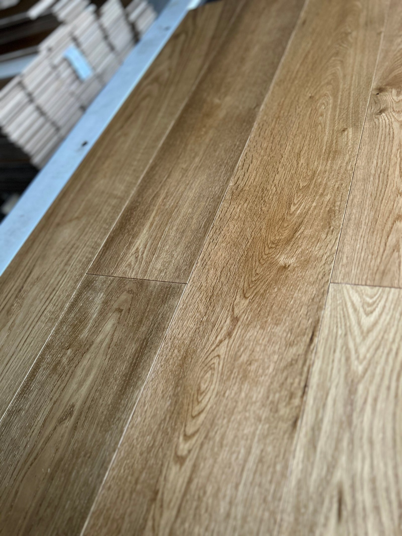 Angled close-up of Warm Wheat oak flooring showing contrasting grain, tonal variation, and staggered board ends