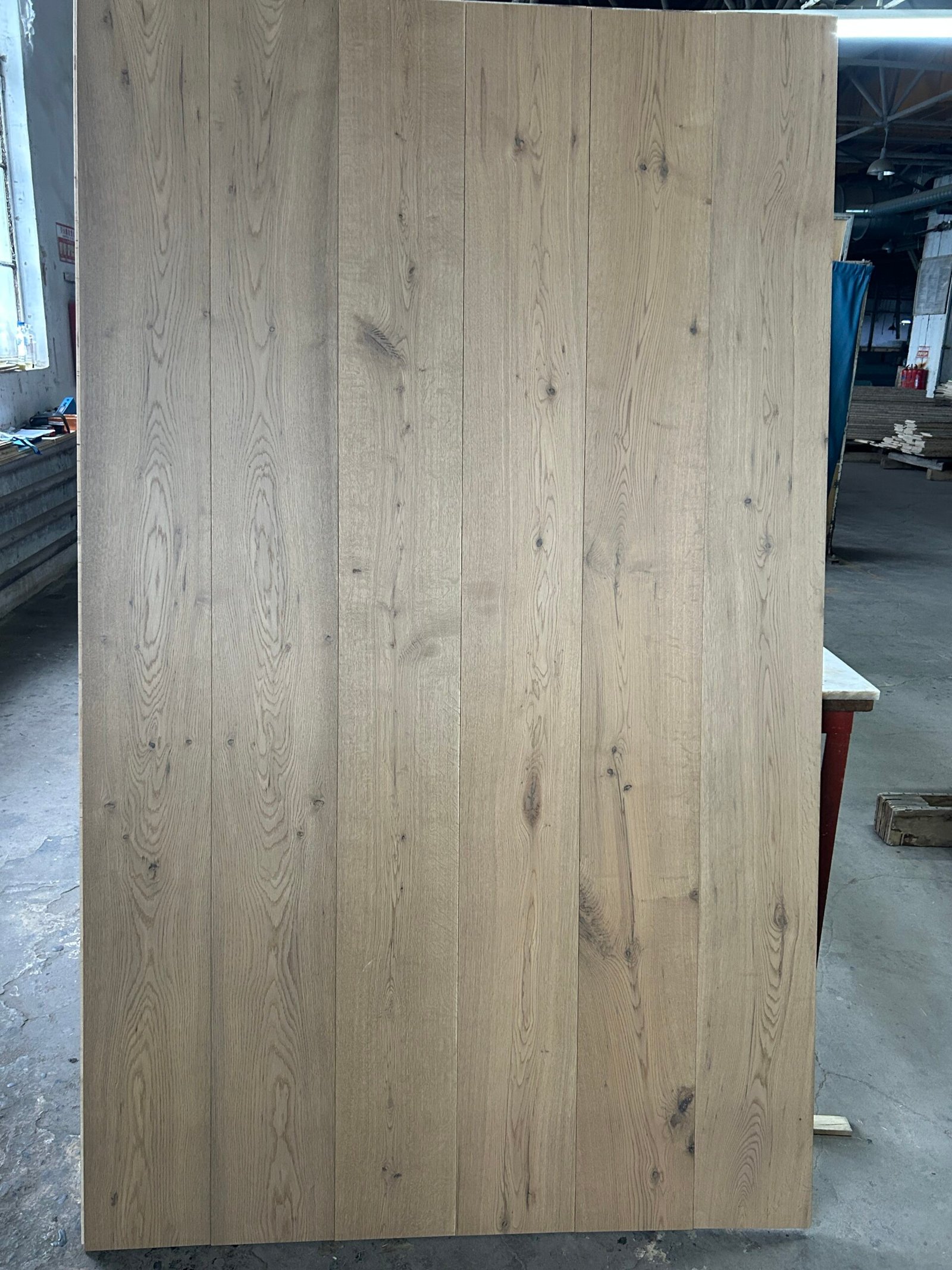 Stone Greige engineered oak flooring boards displayed upright, showing gray-beige tones, visible knots, and natural grain variation