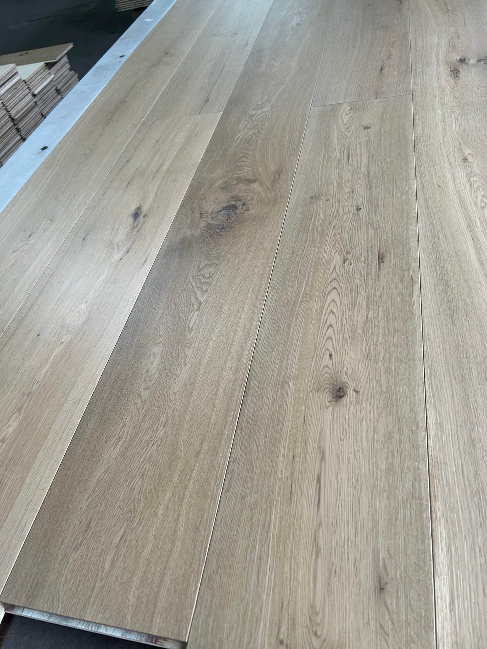 Angled close-up of Mist Grey oak flooring showing contrasting grain, dark knots, and board joints