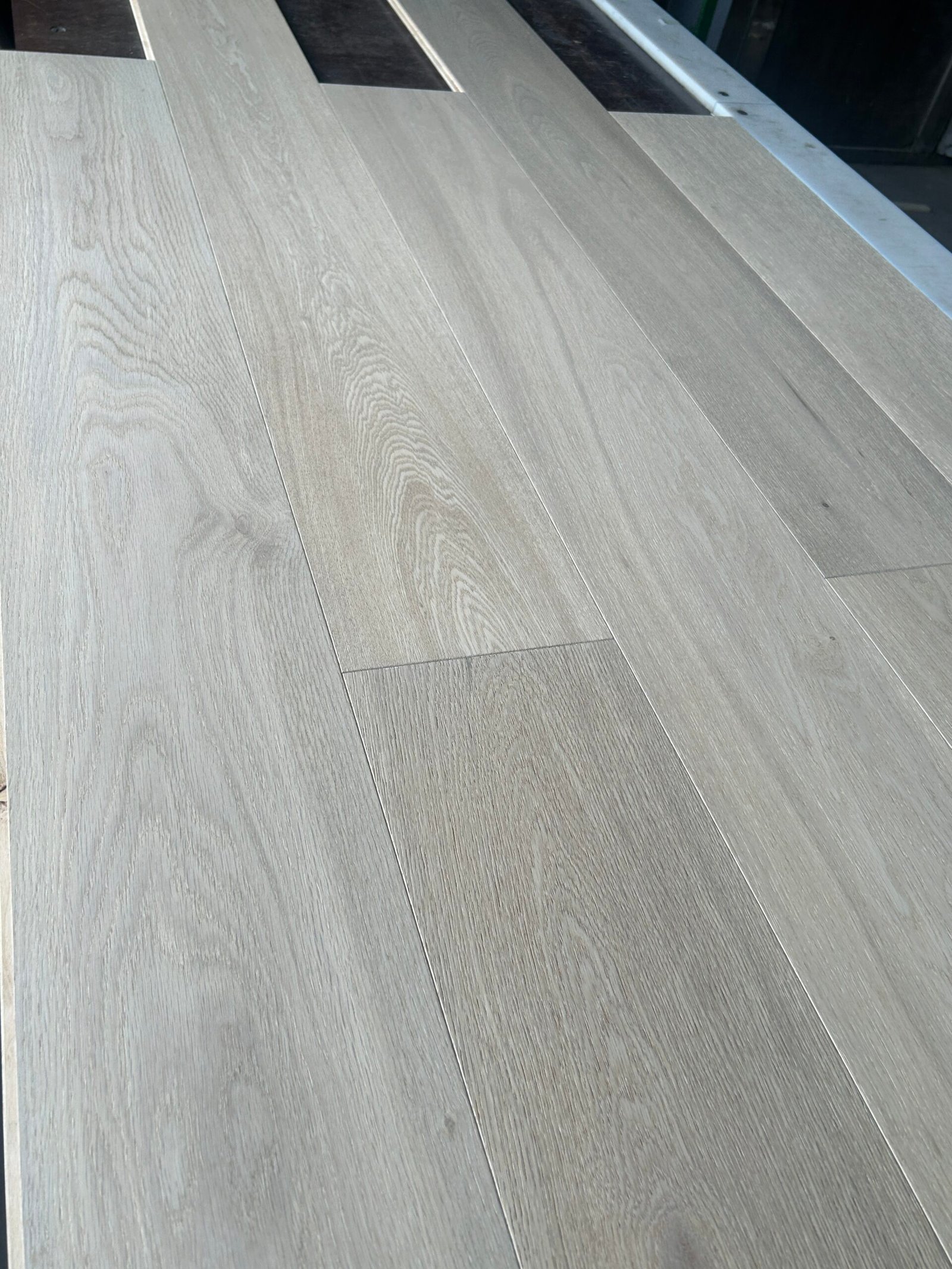 Angled close-up of Natural Sand oak flooring showing natural grain, tonal variation, and staggered board joints
