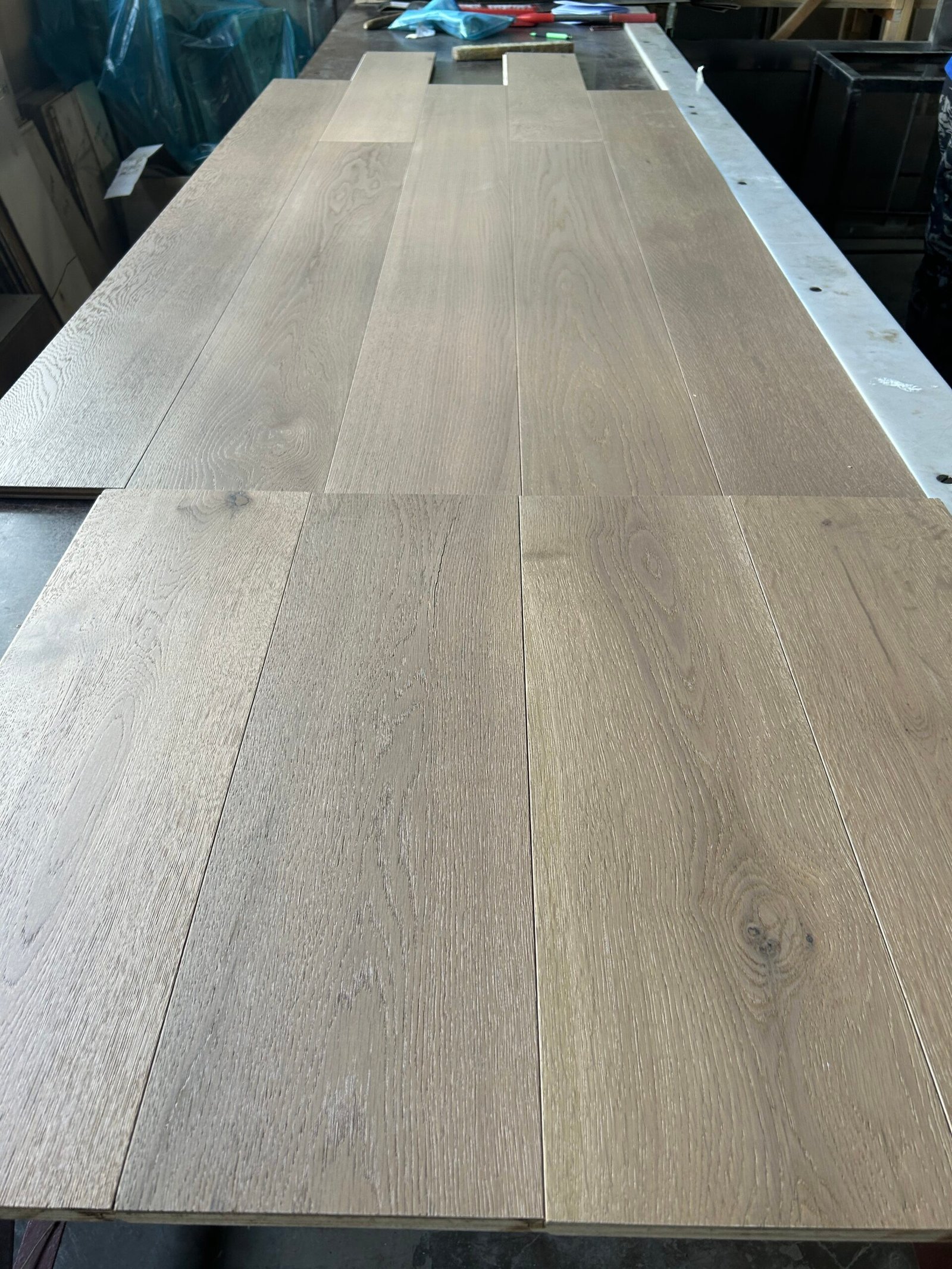 Angled view of Linen Beige oak boards showing natural grain, visible knots, and staggered board joints
