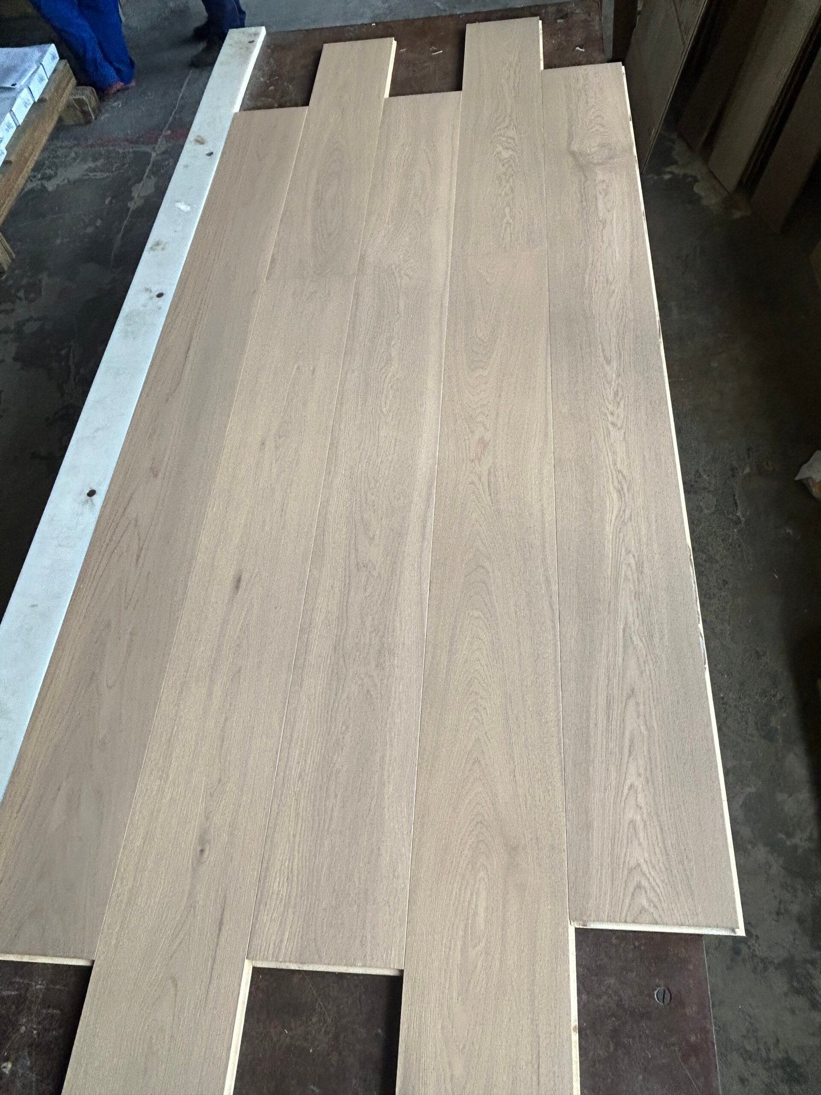 Linen Beige engineered oak flooring boards arranged on a table, showing light greige tones and natural grain