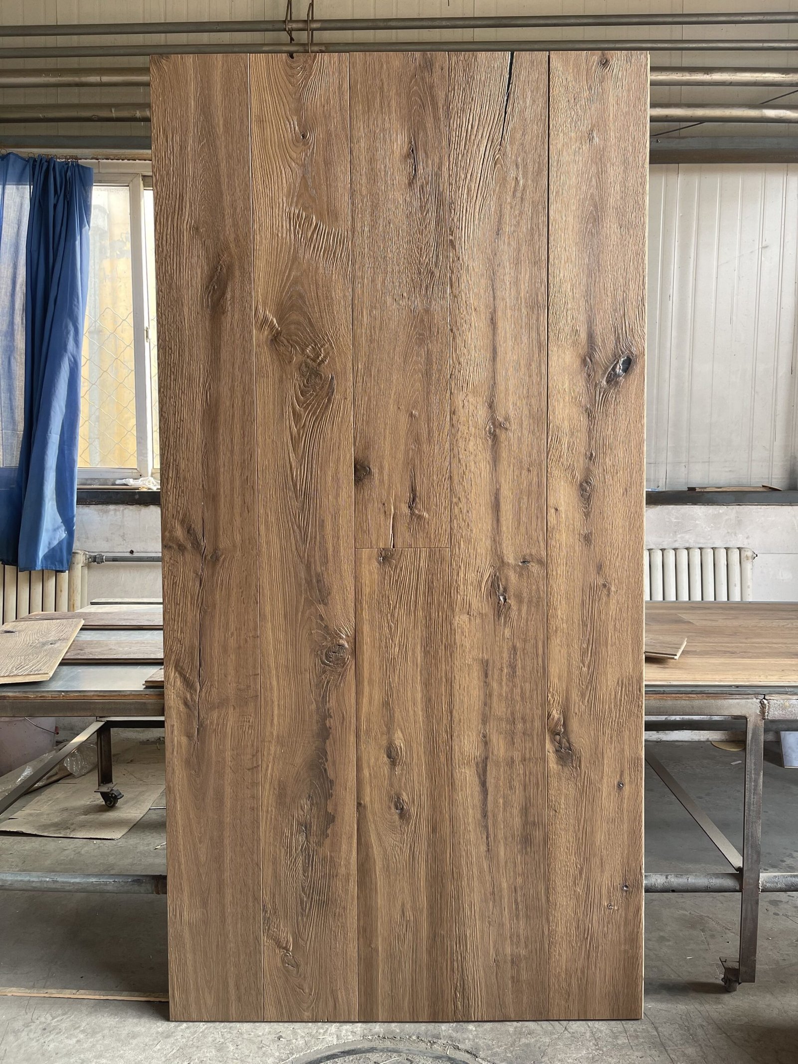 Upright display panel of textured oak flooring showing board arrangement, knots, and tonal variation